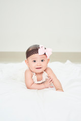 Baby girl smiling on the floor isolated on white