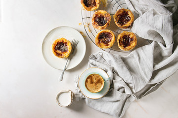 Traditional Portuguese egg tart dessert Pasteis Pastel de nata on cooling rack and ceramic plate...