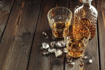 Whiskey glass and bottle on the old wooden table