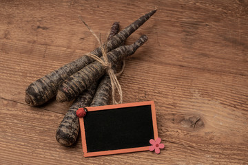 red carrots with a chalkboard on a wooden table