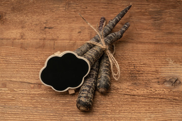 red carrots with a chalkboard on a wooden table