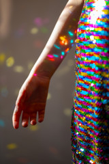 Sequin dress with girls arm with colourful reflections