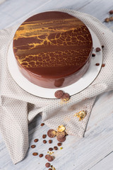 A mousse cake with chocolate and fruits on the white wooden background