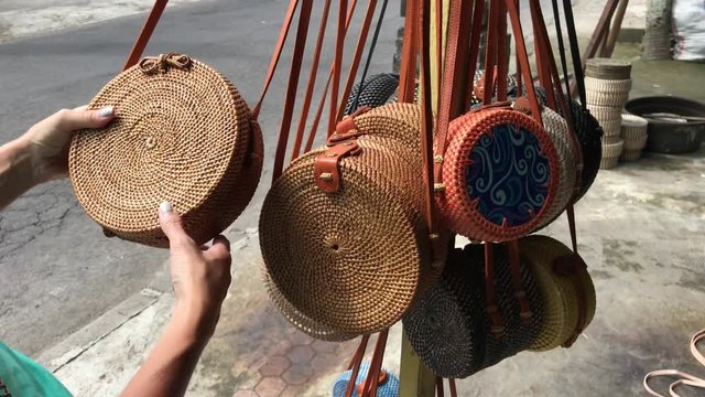 Woman choosing rattan eco bags in the art shop on Bali island, Indonesia. Woman stylish eco bag.
