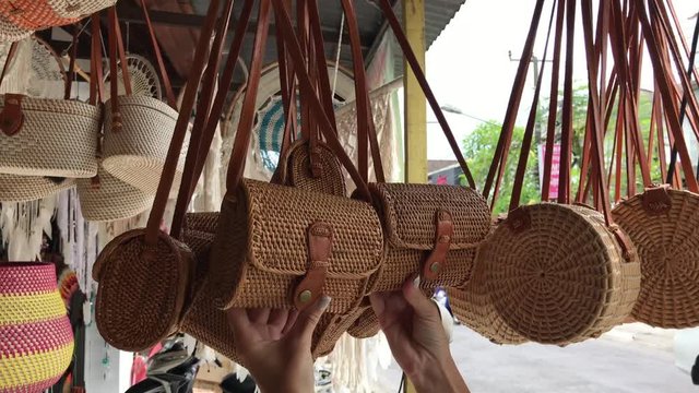 Woman choosing rattan eco bags in the art shop on Bali island, Indonesia. Woman stylish eco bag.