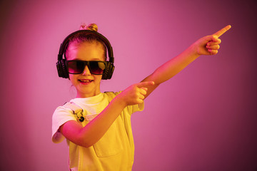 Neon portrait of young girl with headphones enjoying music. Lifestyle of young people, human...