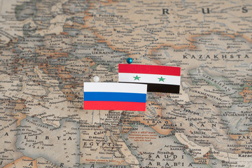 Flags of Russia and Syria on the world map. Conceptual photo, politics and world order