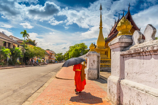 A Buddhist monk walks by the Wat Sen Temple in Luang Prabang, Laos.
