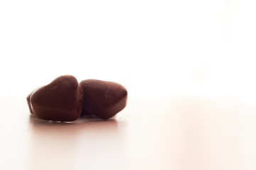 Chocolate heart candies on white background with copy space