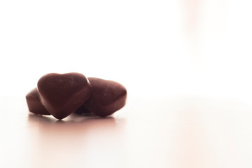 Chocolate heart candies on white background with copy space
