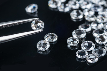 old cut diamonds with tweezer on black background