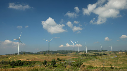 Windmill farm with blue sky and clouds
