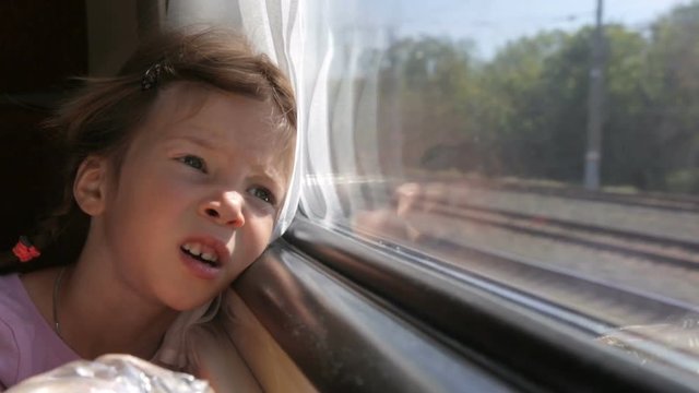 Little girl looking through the window in the train