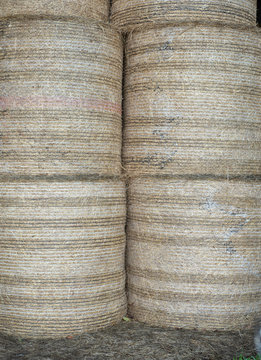 Vertical image of stacked hay bales on a farm
