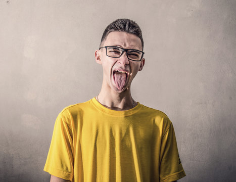 ragazzo con maglietta gialla ed espressione con linguaccia