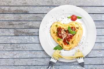 Pasta with tomato sauce in shape of heart with two forks