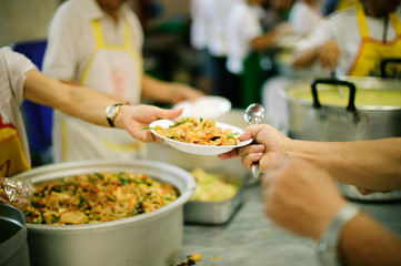 The poor people bring a container to scoop food to eat and relieve hunger and bring home.