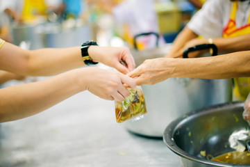 The poor people bring a container to scoop food to eat and relieve hunger and bring home.