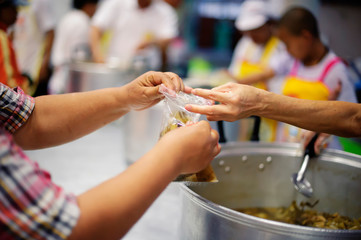 Philanthropists donate food to the poor, share food, help each other in society.