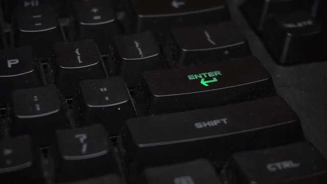 Key blinks Enter on glowing computer keyboard