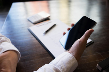 Close up of a man using mobile smart phone on the table