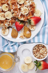 Belgian waffles with syrup, berries and honey, breakfast on a light background, Selective focus