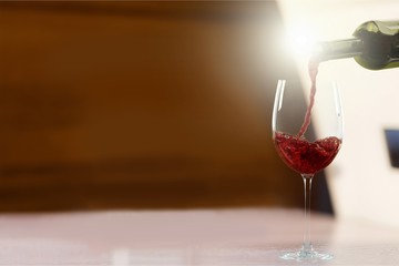 Red wine glass and bootle on wooden table