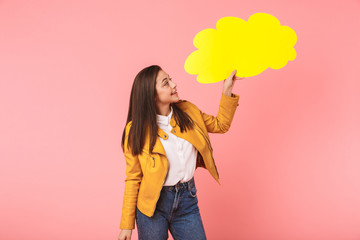 Photo of smiling girl 15-16y in casual holding copyspace placard, isolated over red background