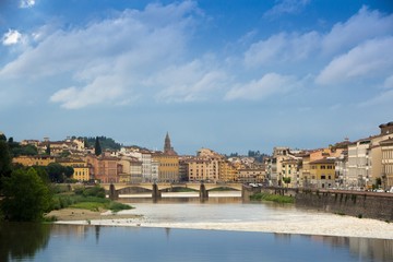 Fototapeta na wymiar The Arno river and the cloudy Florence. Rainy weather with dark blue clouds hanging over the Italian city - Florence.