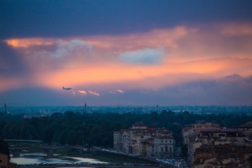 The plane flies over Florence in the evening. Beautiful dramatic sunset over Florence, Italy.