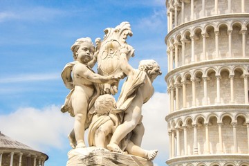 Fototapeta na wymiar Fontana dei Putti and Leaning Tower of Pisa (Torre pendente di Pisa) in Piazza dei Miracoli (Square of Miracles) in Pisa, Italy