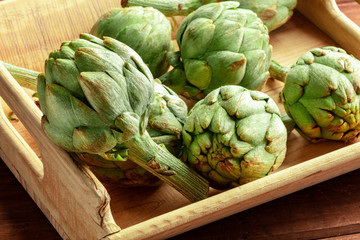 Fototapeta premium A closeup of a globe artichoke in a wooden crate
