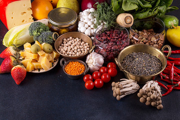 Still life food set on dark background. Concept healthy eating. Broccoli, chicory, beans, lentils, chili, nut, cheese, garlic, spinach, mushrooms shimidzhi, cherry tomato.