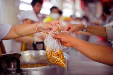 The hands of the hungry get food from the hands of volunteers : concept of hunger poverty
