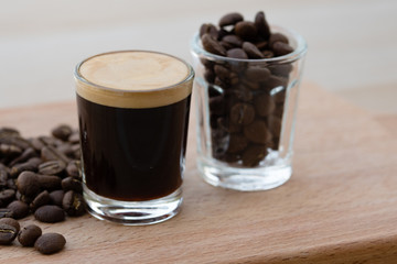 Cups of coffee, one with espresso, one with coffee beans