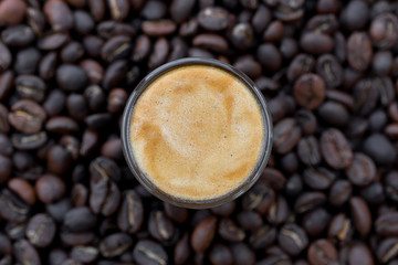 Cup of coffee surrounded with coffee beans