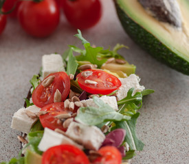 An avocado sandwich with tomatoes and cheeses. serving on the table	