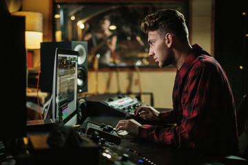 Fototapeta na wymiar Sound engineer working in a music studio