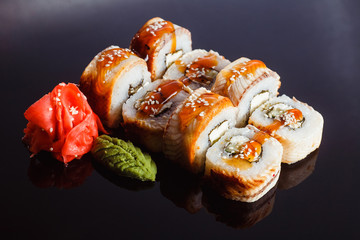 Sushi rolls Unagi with eel on a black background. Traditional Japanese cuisine