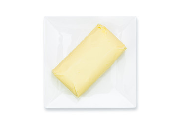 Top view of fresh organic butter block on the plate isolated on a white background in close-up 