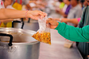 Poor people bring containers to contain food from the sharing of the rich.