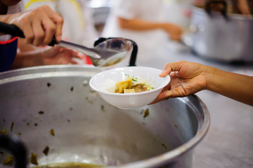 Poor people bring containers to contain food from the sharing of the rich.