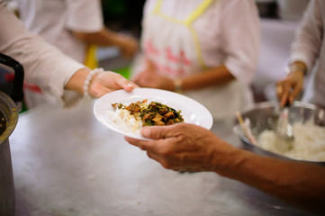 Volunteers are giving food to the homeless poor :  the concept of humane