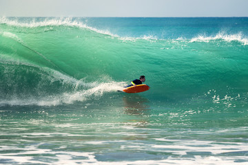man surfing a big wave at full speed