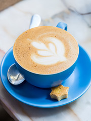 Cappuccino with latte art in a blue cup