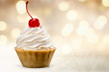 Cupcake with whipped cream and cherry