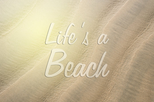 full frame image of a beach sand with LIFE'S A BEACH word. concept of holiday, travel and wanderlust