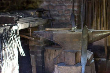 Fototapeta na wymiar A hammer and a metal object in the forge