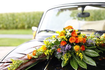 black wedding car decorated with colorful flowers on a sunny day