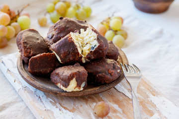 Alternative cheeses without milk from millet, coconut chips and raisins, covered with homemade chocolate. healthy vegan sweets